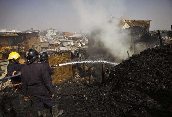 Firefighters spray water as they try to douse a fire in a shanty in Mumbai. A fire has swept through a slum in India`s financial capital Mumbai killing six people and injuring at least seven others.
