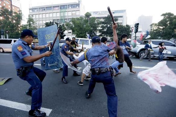 Police hit protesters after the latter managed to throw paint at the seal of the U.S. Embassy in Manila.