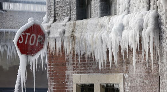 Ice forms on a stop sign and the side of a burned out warehouse after a fire reignited in Chicago.