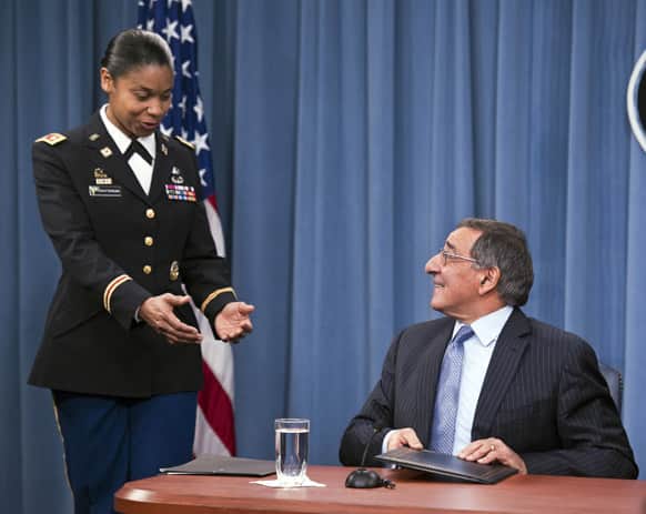 Army Lt. Col. Tamatha Patterson, of Huntingdon, Tenn., waits for Defense Secretary Leon Panetta to hand her the memorandum he has just signed ending the 1994 ban on women serving in combat during a news conference at the Pentagon.