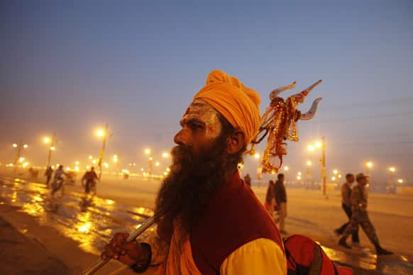 A Hindu holy man carrying a Trident, walks at Sangam, the confluence of rivers Ganges and Yamuna during the Maha Kumbh festival in Allahabad.