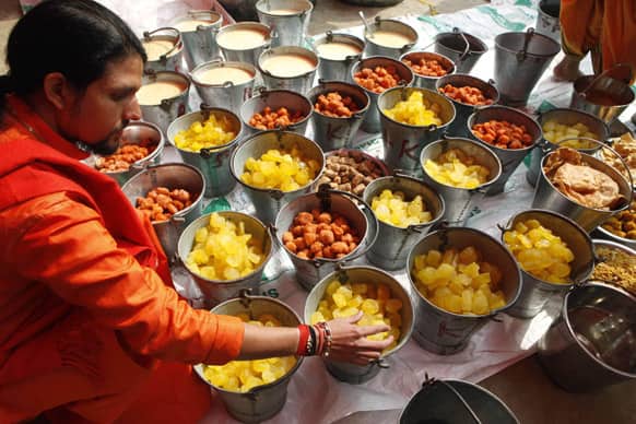 Hindu holy man Anand Giri checks delicacies before being served in a community feast at Sangam, the confluence of the Ganges and Yamuna River during the Maha Kumbh festival in Allahabad.