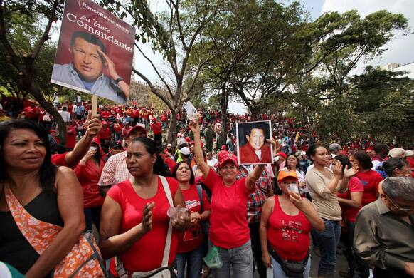 Supporters of Venezuela`s President Hugo Chavez hold photos of him at an event commemorating the 1958 fall of the country`s dictatorship in Caracas, Venezuela.