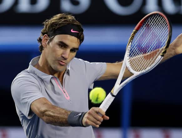 Switzerland`s Roger Federer hits a backhand return to France`s Jo-Wilfried Tsonga during their quarterfinal match at the Australian Open tennis championship in Melbourne.
