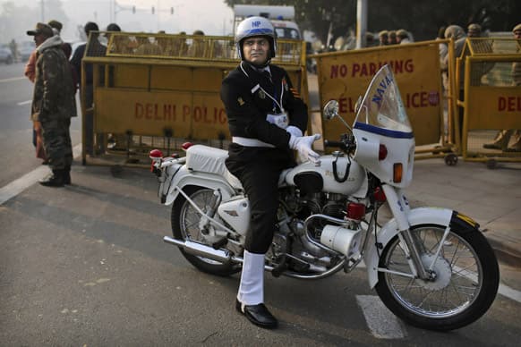 An Indian naval police officer puts on his white gloves as he waits before a dress rehearsal for the annual Republic Day parade in New Delhi.