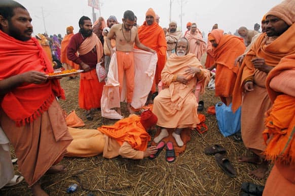 A Hindu holy man, prostrates as he pays respect to a senior holy man at Sangam, the confluence of the rivers Ganges and Yamuna during the Maha Kumbh festival in Allahabad.