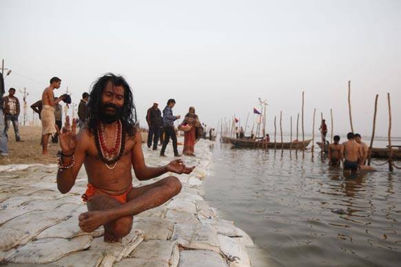 A Hindu holy man performs yoga at Sangam, the confluence of the Ganges, and Yamuna during the Maha Kumbh Mela, in Allahabad.