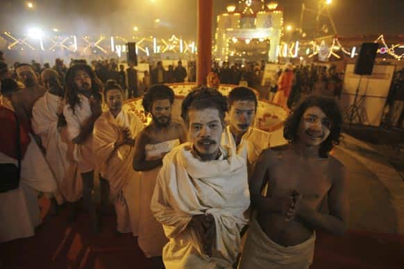 Hindu holy men perform evening prayers at Sangam, the confluence of the Ganges, and Yamuna during the Maha Kumbh Mela, in Allahabad.