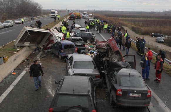 Emergency workers search the site of a fatal car crash on the Egnatia Highway in the village of Kleidi near the northern Greek port city of Thessaloniki. One person was killed and 24 others were injured in two nearby pile-ups that occurred amid heavy fog in the area.