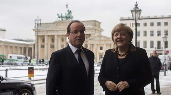 French President Francois Hollande, welcomes German Chancellor Angela Merkel in front of the Brandenburg Gate near the France embassy in Berlin.