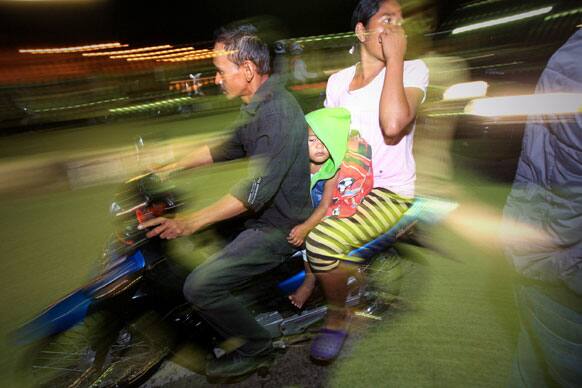 People on motorcycles flee after a strong earthquake hit in Aceh, Indonesia. A strong, shallow earthquake rocked parts of western Indonesia early Tuesday, killing a 9-year-old girl, panicking residents and ruining homes. Several other people were injured.
