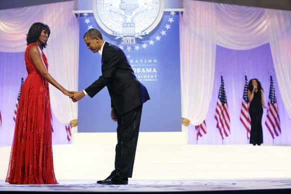 President Barack Obama bows as he and first lady Michelle Obama, wearing a ruby colored chiffon and velvet Jason Wu gown, gets ready to dance as singer Jennifer Hudson sings Al Green`s
