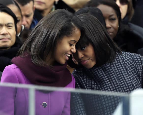 First lady Michelle Obama speaks with her daughter Malia at the ceremonial swearing-in for President Barack Obama at the US Capitol during the 57th Presidential Inauguration in Washington.