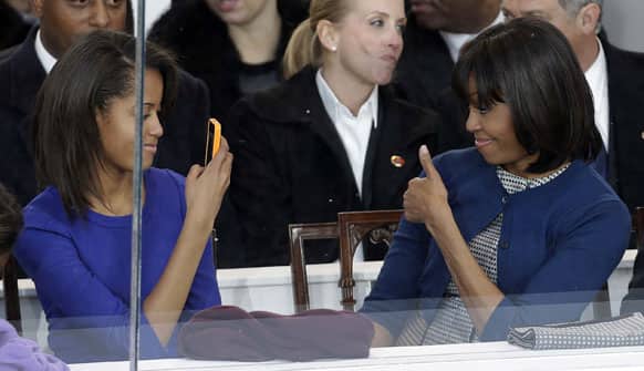 First lady Michelle Obama poses for photographs for her daughter Malia during the inaugural parade in Washington.