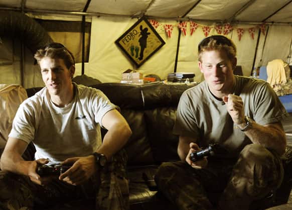 In this photo taken Nov. 3, 2012, & made available Jan. 21, 2013 of Britain`s Prince Harry, right, or just plain Captain Wales as he is known in the British Army, reacts as he plays computer games with his fellow Apache Helicopter crew, during his 12 hour VHR shift at the British controlled flight-line.