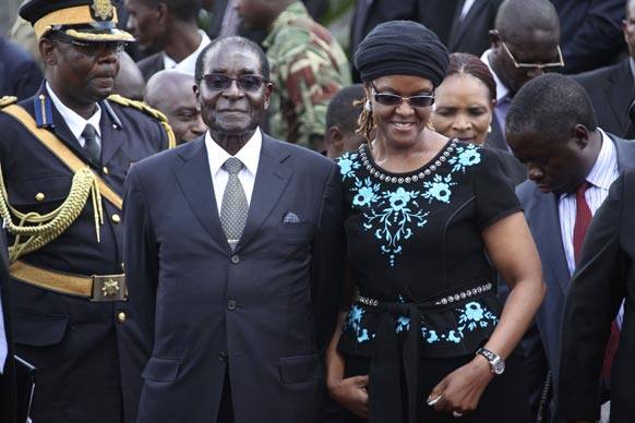 Zimbabwean President Robert Mugabe, left, and his wife Grace attend the burial of Deputy President John Nkomo, at the Heroes Acre, in Harare, Zimbabwe.