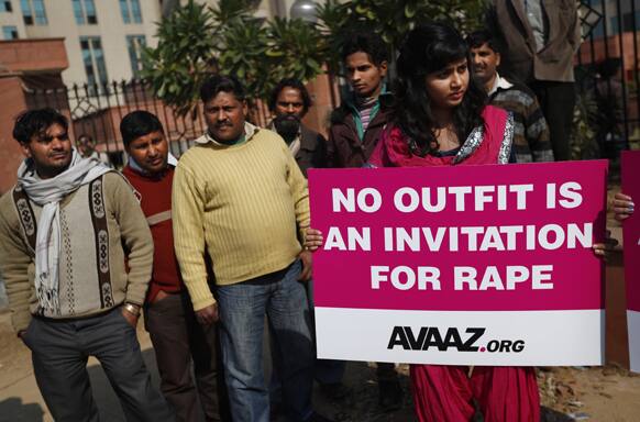 Men watch as a woman protests outside the court where the accused in a gang rape of a 23-year-old woman are to be tried, in New Delhi.