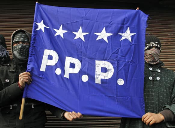 Activists of People`s Political Party (PPP) hold their party flag during a memorial service to mark the 23rd anniversary of an alleged massacre in Srinagar.