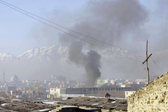 Smoke rises from the building of Kabul traffic police headquarters during insurgents` attack, in Kabul, Afghanistan. Taliban insurgents wearing suicide vests attacked the headquarters before dawn Monday, police said.