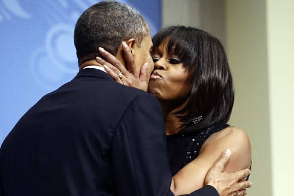 President Barack Obama kisses first lady Michelle Obama as they speak to supporters and donors at an inaugural reception for the 57th Presidential Inauguration at The National Building Museum in Washington.