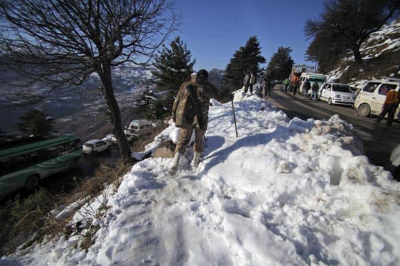 An Indian security man patrols near stranded vehicles on the Jammu-Srinagar National Highway in Patnitop about 110 kilometers (63 miles) from Jammu.