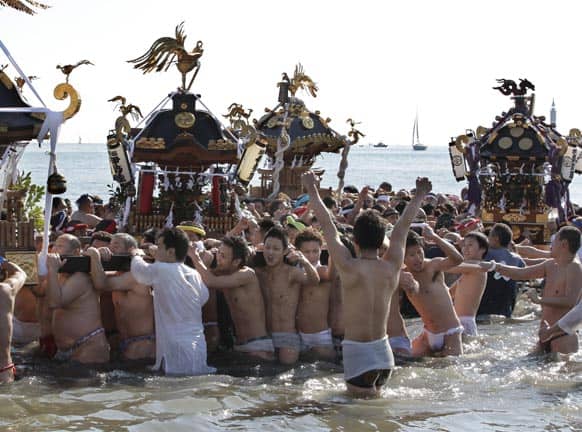 Participants carry a portable shrine and parade through the sea during a mid-winter festival at Enoshima beach in Fujisawa, west of Tokyo.