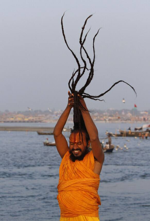A Sadhu, or Hindu holy man, ties his hair at Sangam, the confluence of the holy rivers Ganges and Yamuna and mythical Saraswati at the Maha Kumbh Mela in Allahabad.