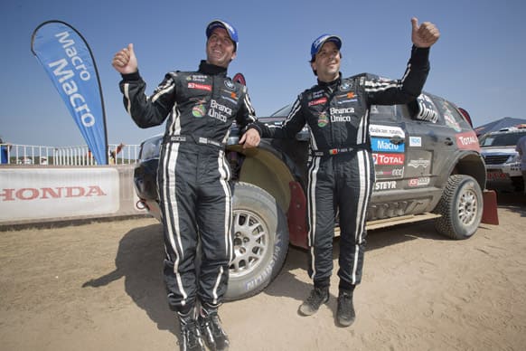Orlando Terranova of Argentina, left, and Paulo Fiuza of Portugal, right, pose in front of their BMW at the end of 2013 Dakar Rally in in the last 14th stage from La Serena to Santiago, Chile.
