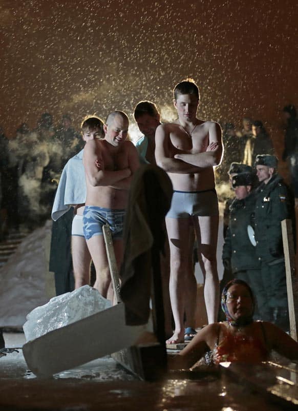 People stand in a queue to the bath of the ice cold water as they take the bath in the ice hole of the pound in the Kolomenskoye park on the outskirts of Moscow.