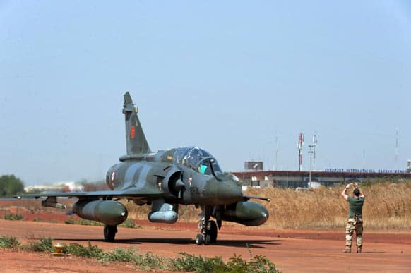 This picture released by the French Army Communications Audiovisual office (ECPAD) a soldier directs a French Mirage 2000D after landing at Bamako airport, Mali.