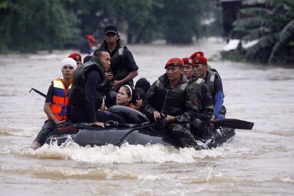 Indonesian special force soldiers evacuate people in a rubber boat in Jakarta. Authorities were working Friday to repair a dike that collapsed amid floods that swamped the Indonesian capital as the waters gradually receded from the main streets of the teeming city.
