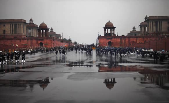 Members of Indian Navy and Air Force walk back to their respective enclosures as rain halts rehearsals for India`s Republic Day parade in New Delhi.
