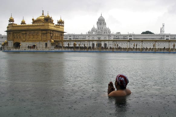A Sikh devotee pays obeisance as he takes a dip in the holy pond on the birth anniversary of the tenth Sikh guru, Gobind Singh, at Golden Temple in Amritsar.