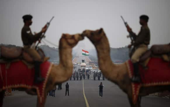 Border Security Force personnel sit on camels during preparations for the upcoming Beating Retreat ceremony near the Presidential Palace in New Delhi.