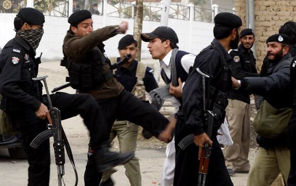 Pakistani police commandos kick a young adult protesting with others against the killings of their family members, in Peshawar. Hundreds of villagers from northwest Pakistan protested against the killing of 18 of their relatives in an overnight raid that they blamed on security forces.
