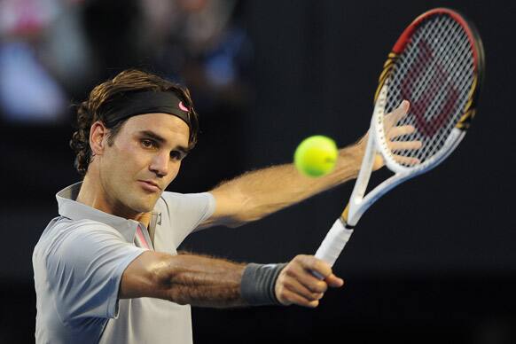 Switzerland`s Roger Federer makes a backhand return to Russia`s Nikolay Davydenko during their second round match at the Australian Open tennis championship in Melbourne.