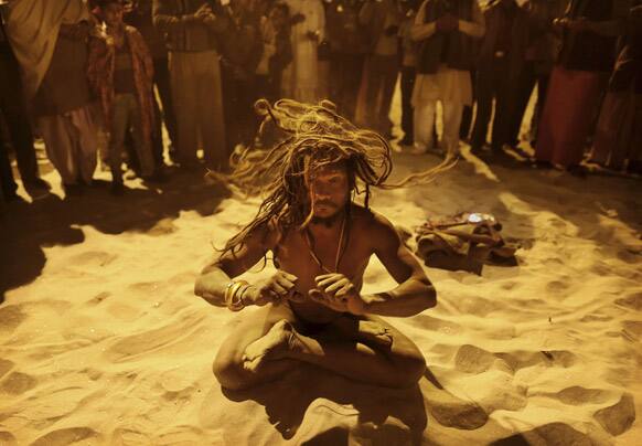 An Indian Hindu holy man, or Naga Sadhu,performs naked following an evening prayer ceremony at Sangam, the confluence of the holy rivers Ganges and Yamuna and mythical Saraswati at the Maha Kumbh Mela in Allahabad.