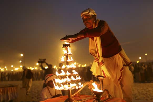 An Indian Hindu priest performs an evening prayer ritual known as Arti, at Sangam, the confluence of the holy rivers Ganges and Yamuna and mythical Saraswati at the Maha Kumbh Mela in Allahabad.