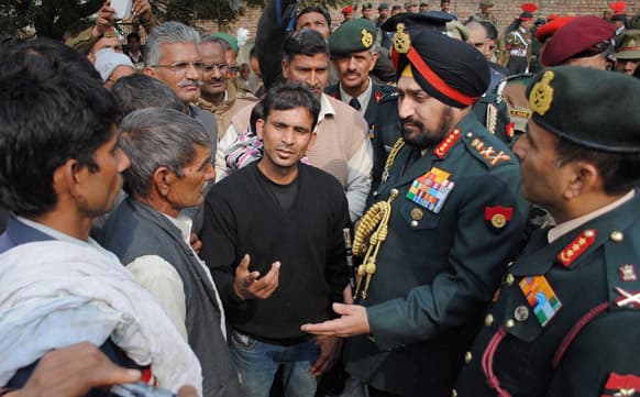 Indian army chief Gen. Bikram Singh speaks with family members of Indian army soldier Lance Naik Hemraj who was allegedly killed by Pakistani soldiers on the Line of Control (LOC), the line that divides Kashmir between India and Pakistan, at Sherpur village.