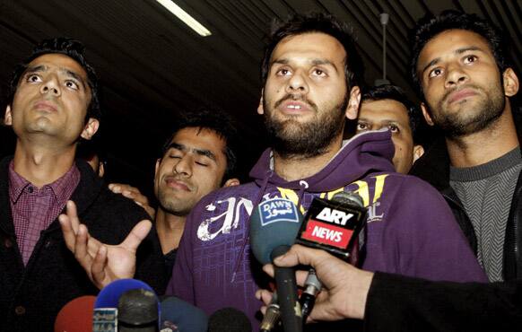 Pakistan hockey player Imran Butt, centre, flanked with other players, talks to reporters at the Lahore airport in Pakistan.