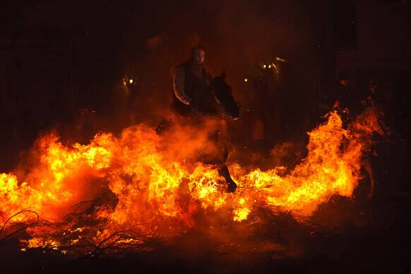 A man rides a horse through a bonfire in San Bartolome de Pinares, Spain, in honor of Saint Anthony, the patron saint of animals.