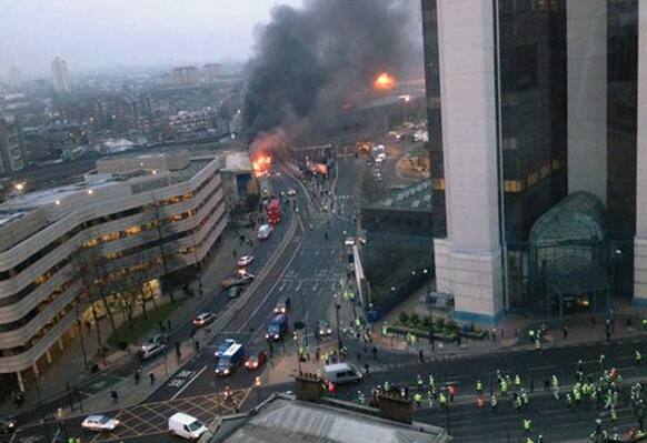 In this overhead view showing smoke and flames at the site of a helicopter crash in central London, as people gather to view the scene shortly after the incident.