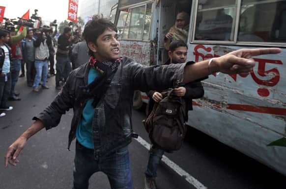 A leftist party activist shouts warning for a bus to stop plying during a half-day strike in Dhaka, Bangladesh. A combination of three left parties, including Communist Party of Bangladesh, called for the strike to protest against an oil price hike.