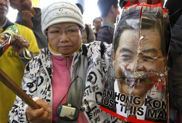 A protester raises a defamed picture of Hong Kong Chief Executive Leung Chun-ying outside the Legislative Council before Leung delivers his policy address in Hong Kong.