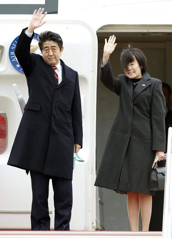 Japanese Prime Minister Shinzo Abe and his wife Akie wave as they prepare to leave for Vietnam, at Haneda airport in Tokyo.