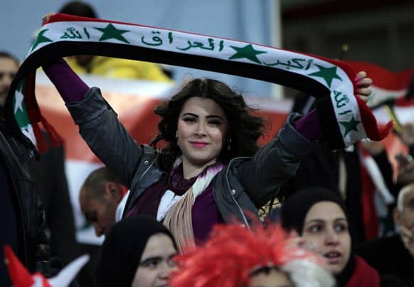 An Iraq fan holds up a scarf with her country`s name and flag during semi-final play at the Gulf Cup soccer tournament in Riffa, Bahrain.