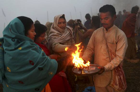 Hindu priest offers blessings to devotees at Sangam, the confluence of the holy rivers Ganges and Yamuna and mythical Saraswati at the Maha Kumbh Mela in Allahabad.