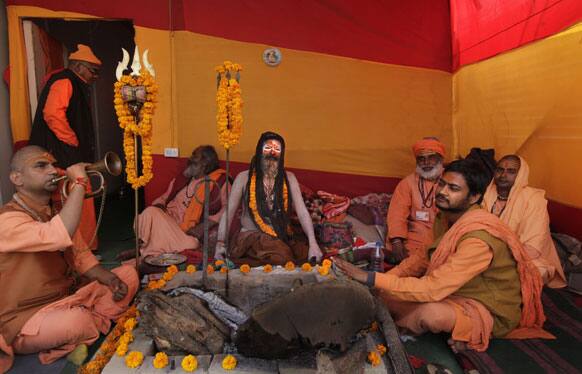Hindu holy men talk sitting outside their camp at Sangam, the confluence of the Rivers Ganges, Yamuna and mythical Saraswati during the Maha Kumbh Mela, in Allahabad.
