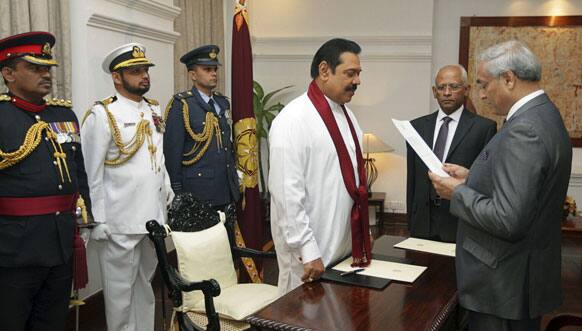 Sri Lankan President Mahinda Rajapaksa, swears in new Chief Justice Mohan Peiris, a retired attorney general and a legal adviser to the Cabinet, as Lalith Weeratunga, secretary to the president, watches in Colombo.