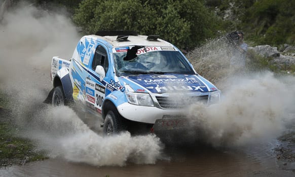 Lucio Alvarez and co-driver Bernardo Graue, both of Argentina, race their Toyota with a broken windshield across a creek during the 9th stage of the 2013 Dakar Rally from Tucuman to Cordoba, Argentina.